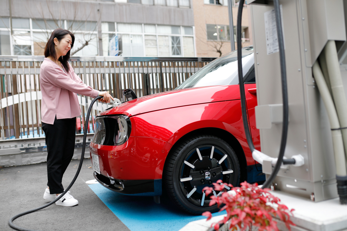 電気自動車（EV）を充電する女性