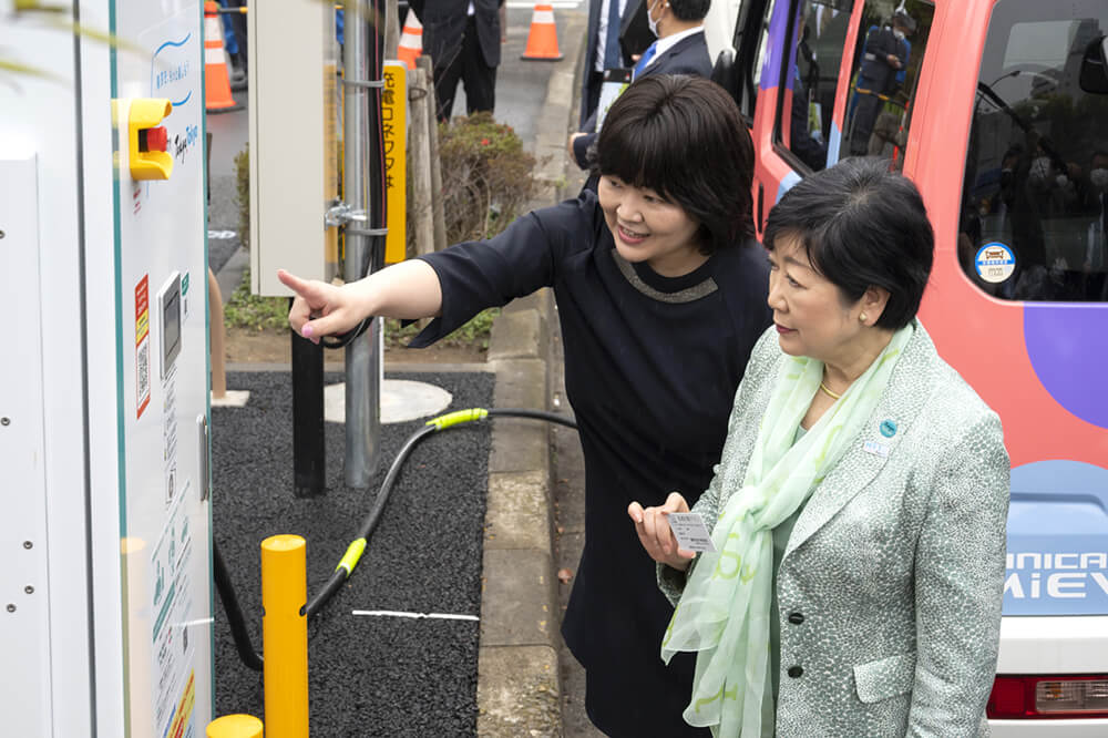 東京タワーパーキングチケットに設置された東光高岳製急速充電器を視察する小池百合子東京都知事と充電器の説明をする四ツ柳社長(東京都提供)