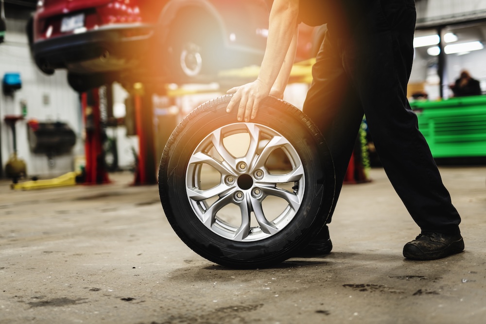 作業中の車のタイヤを交換する整備士のホイールのクローズビュー 