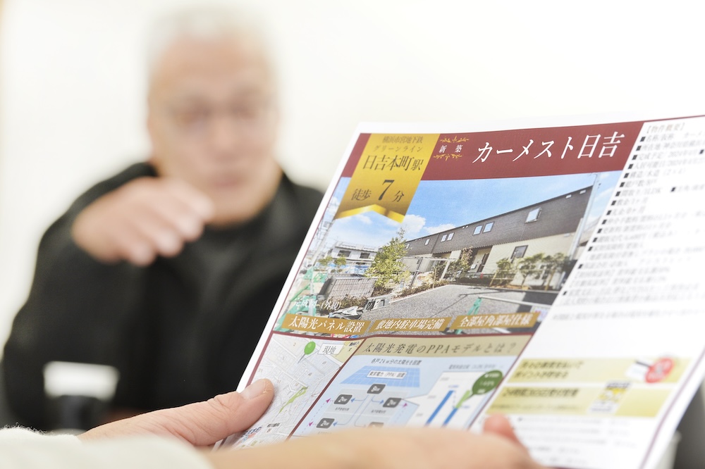 チラシ越しに話をするS様