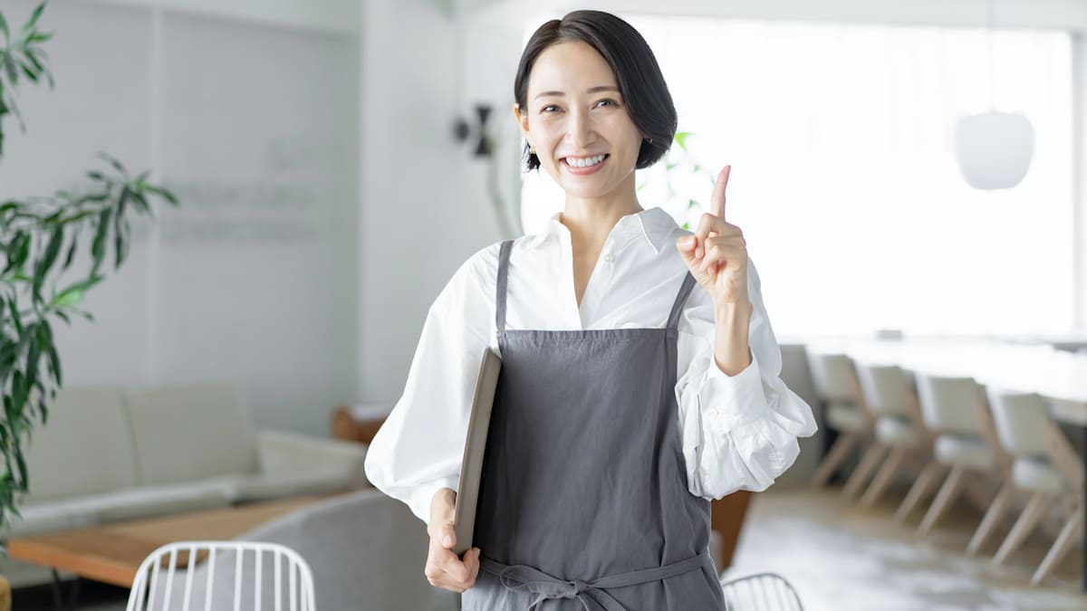 人差し指を立てているカフェの店員