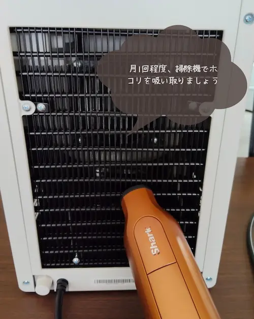浄水型ウォーターサーバー・ピュアライフSの背面のホコリを掃除機で吸い取る様子