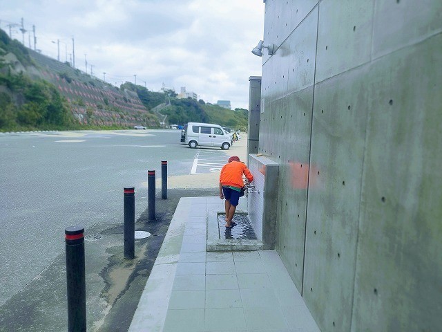 トイレ前の水道で足を洗う息子