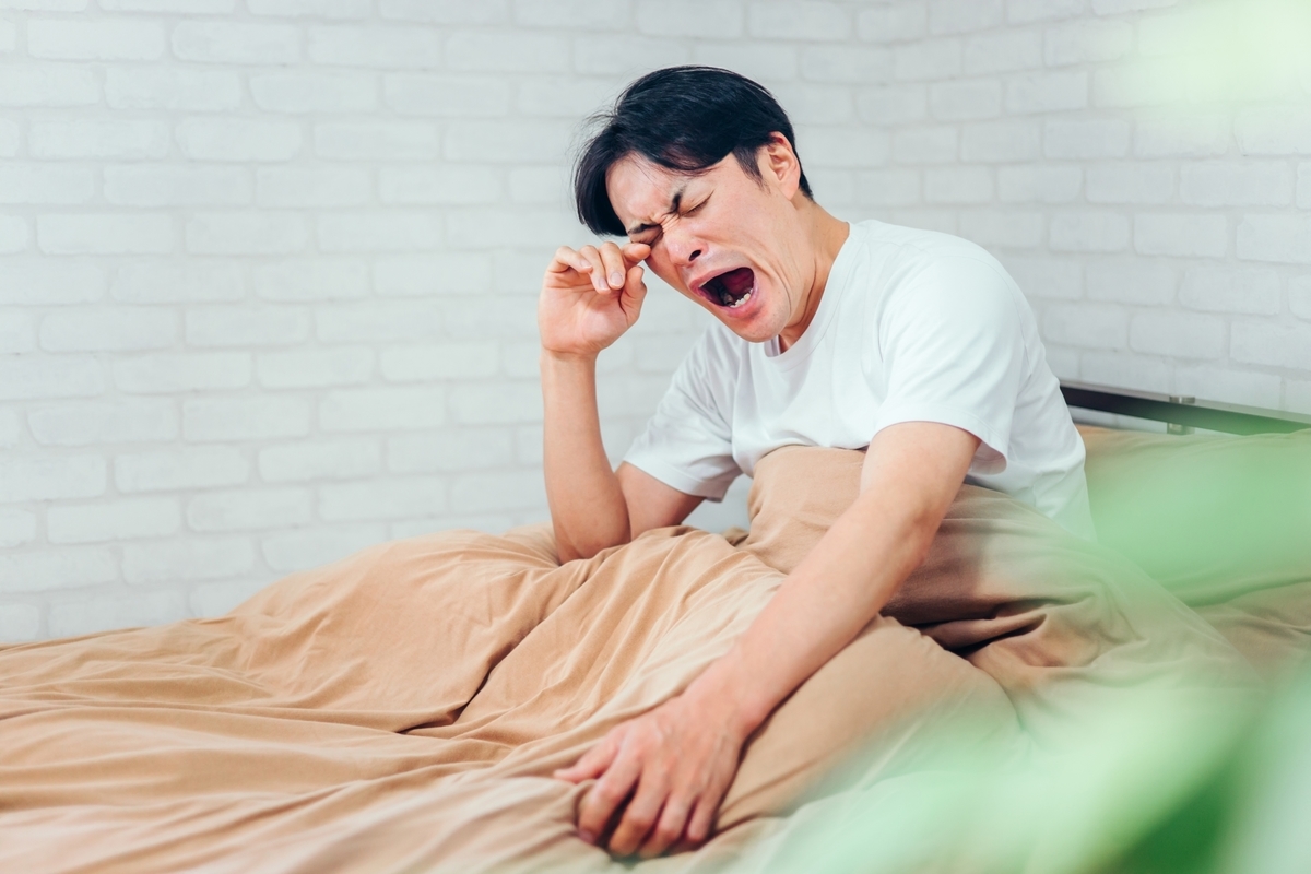 不眠で寝起きが眠い男性の写真