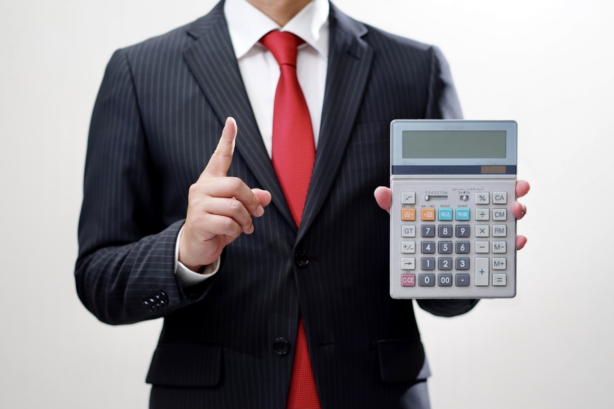 電卓を持つスーツの男性