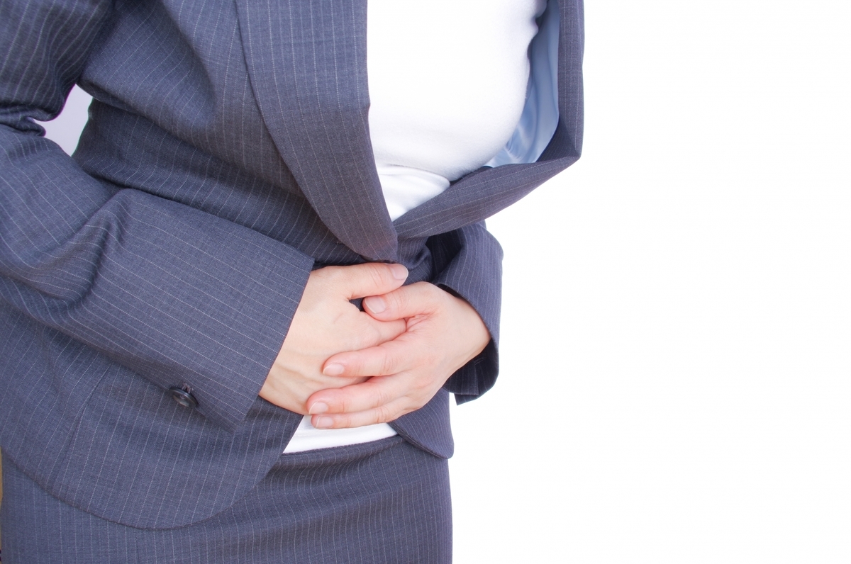 腹痛を押さえる女性