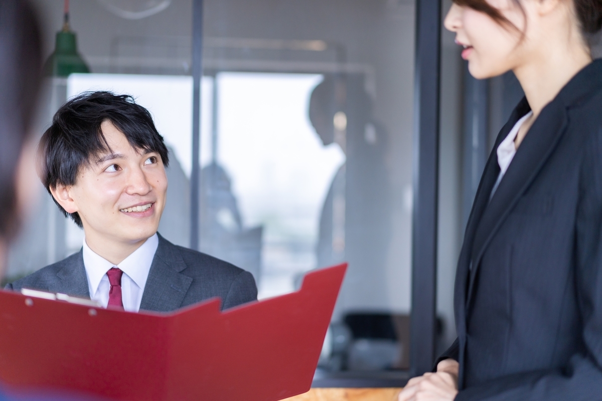 資料を見て会話する女性