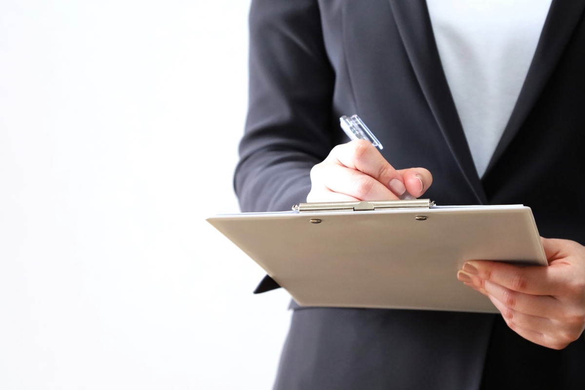 チェックをつけるスーツの女性