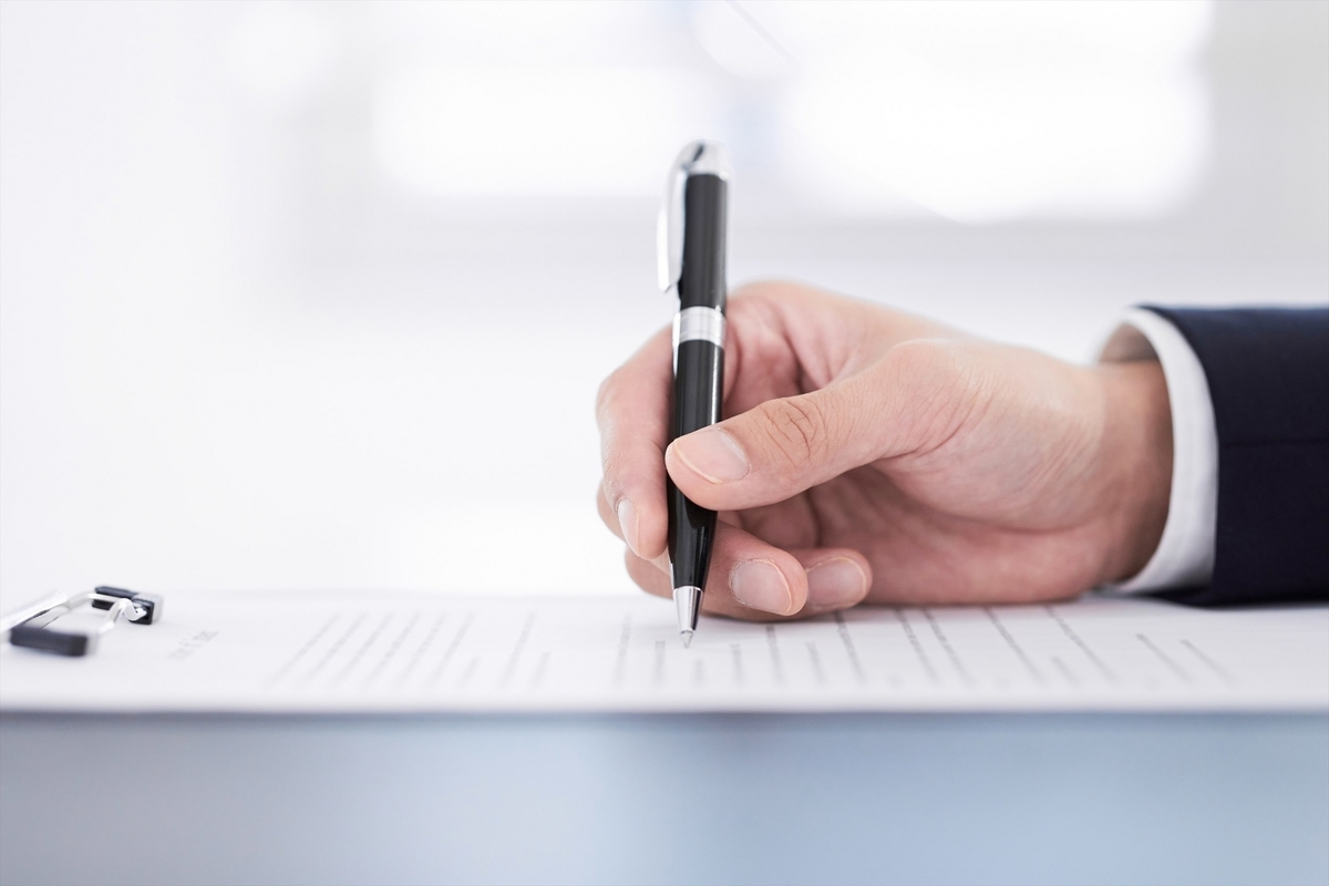 書類に記入する男性の手元