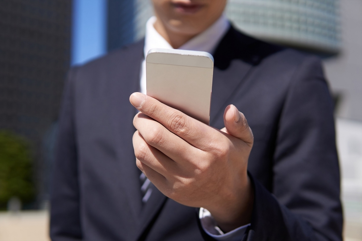 スマホを見るスーツの男性
