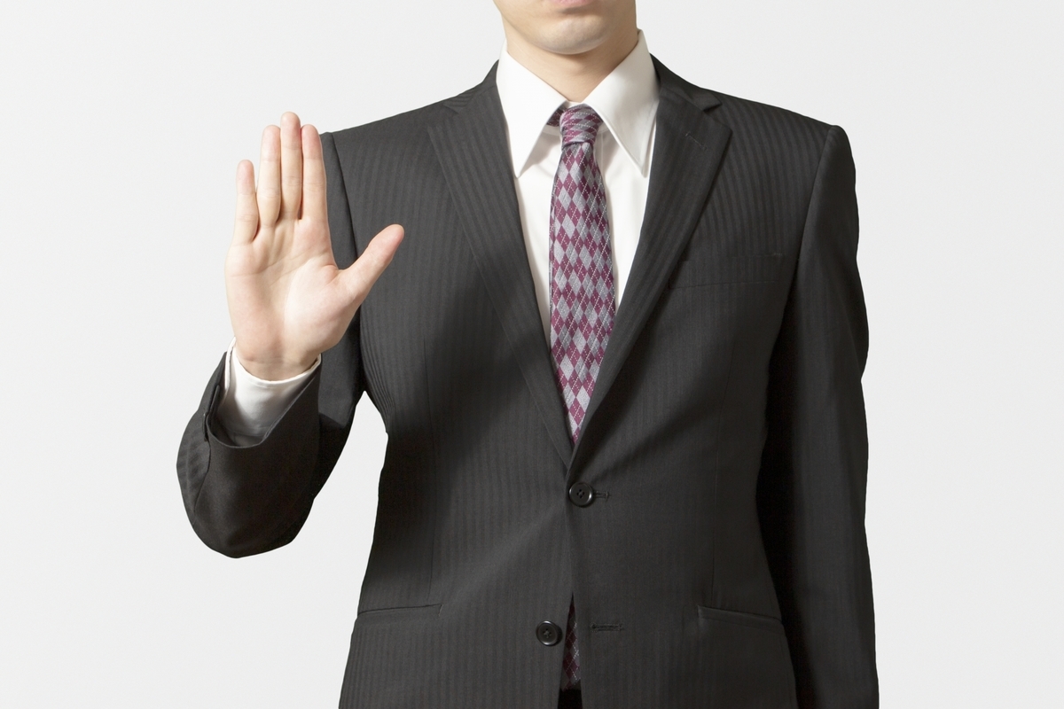 挙手をするスーツの男性