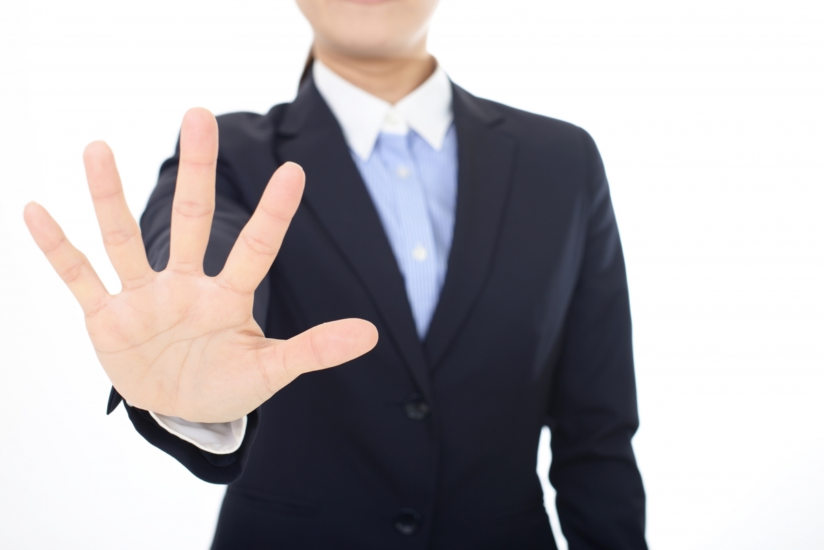 手を広げて制止をするスーツの人物
