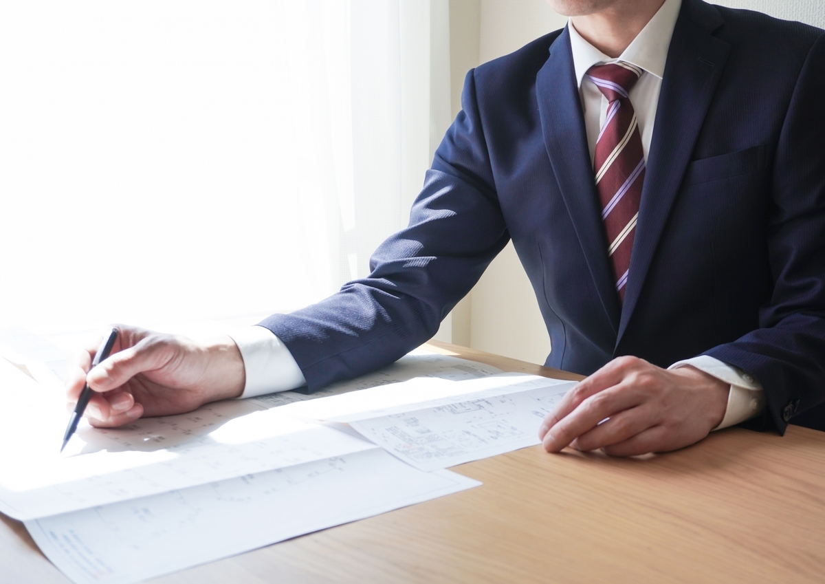資料に記入するスーツの男性