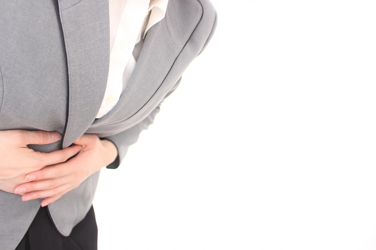 おなかを押さえている女性