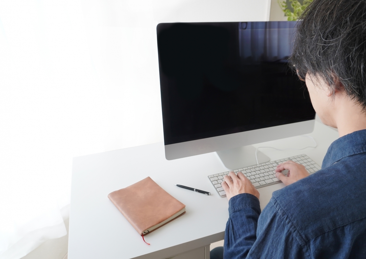パソコンに向かいデスクワークする男性
