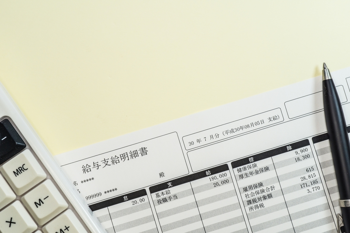 給与明細とペンと電卓