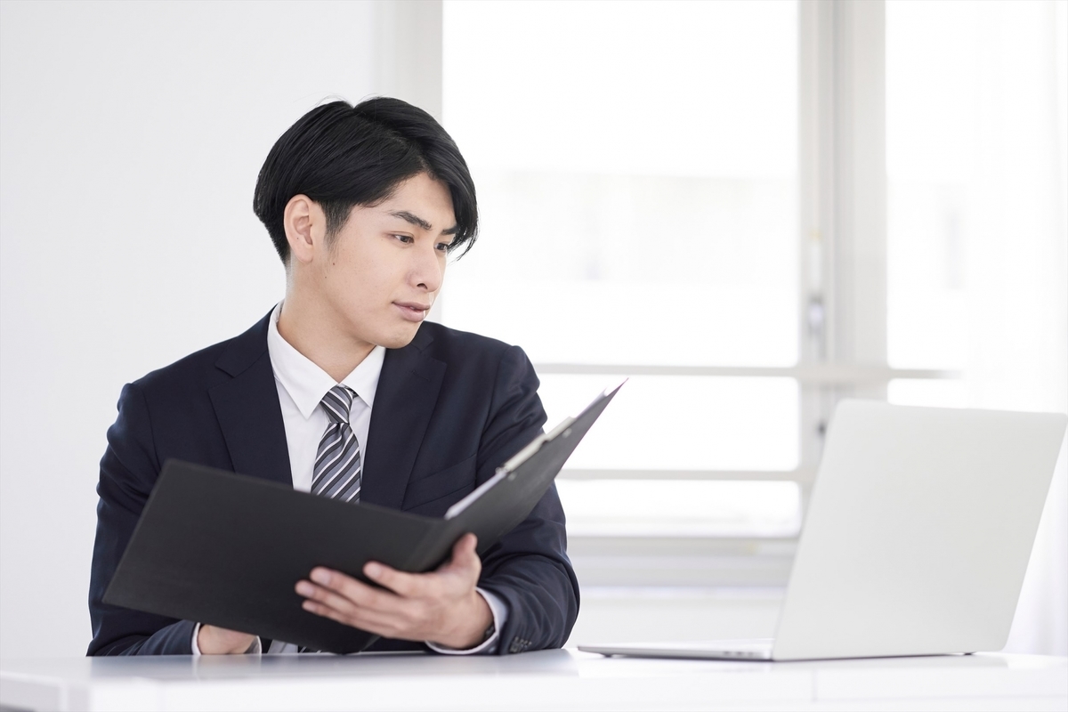 パソコンを見ながら資料を確認する男性