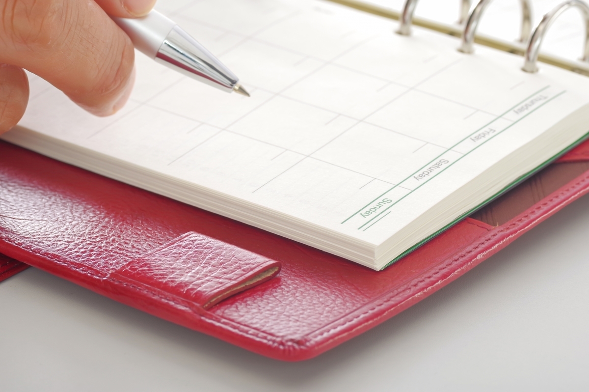 手帳に記入する手元