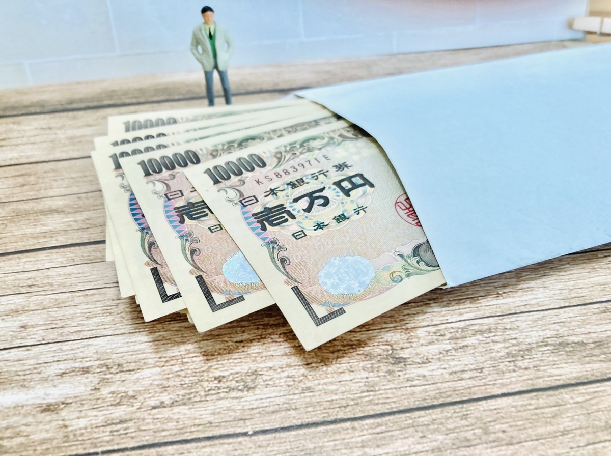 一万円札と封筒に小さな人形