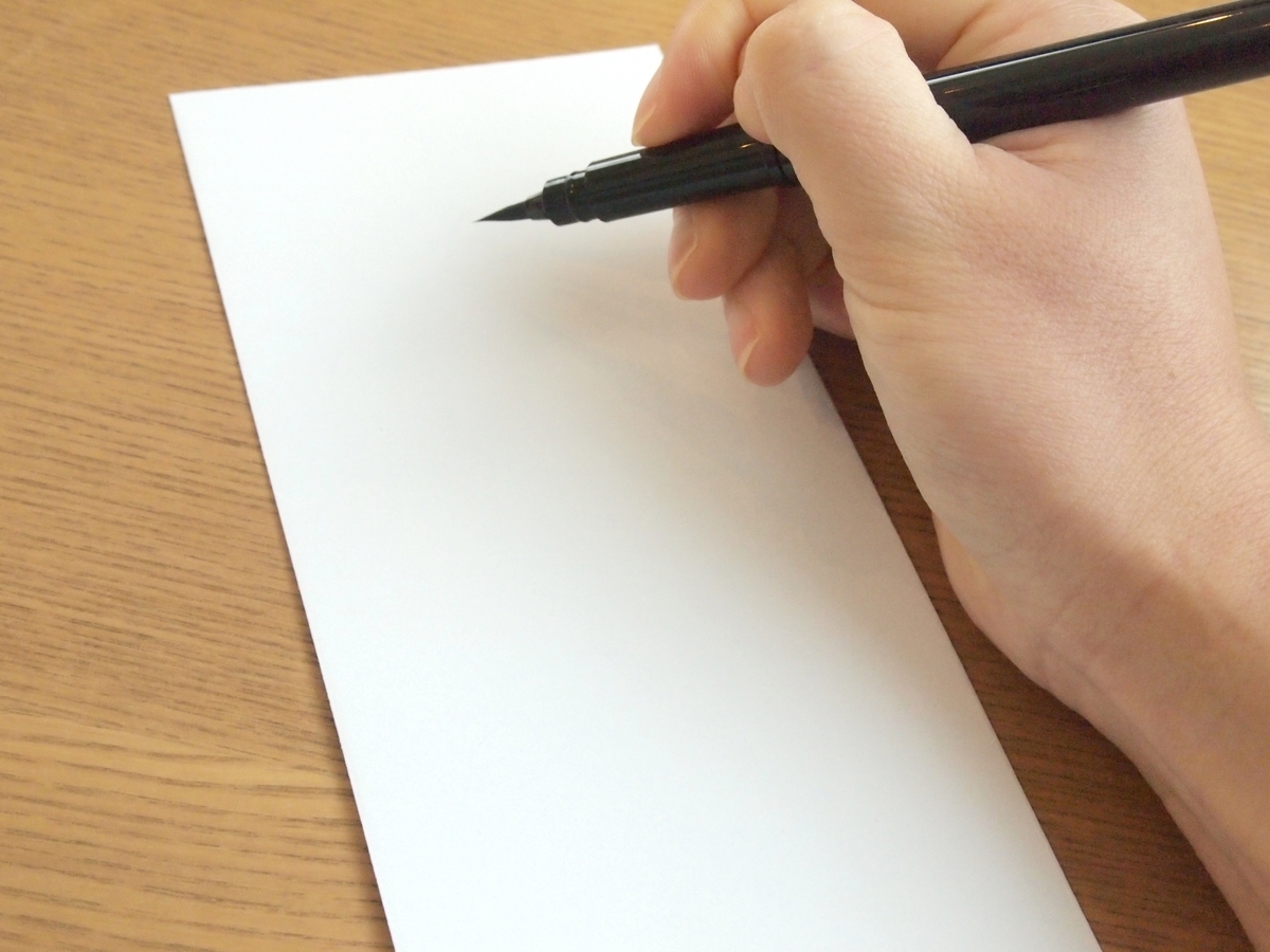 封筒に記入しようとする人