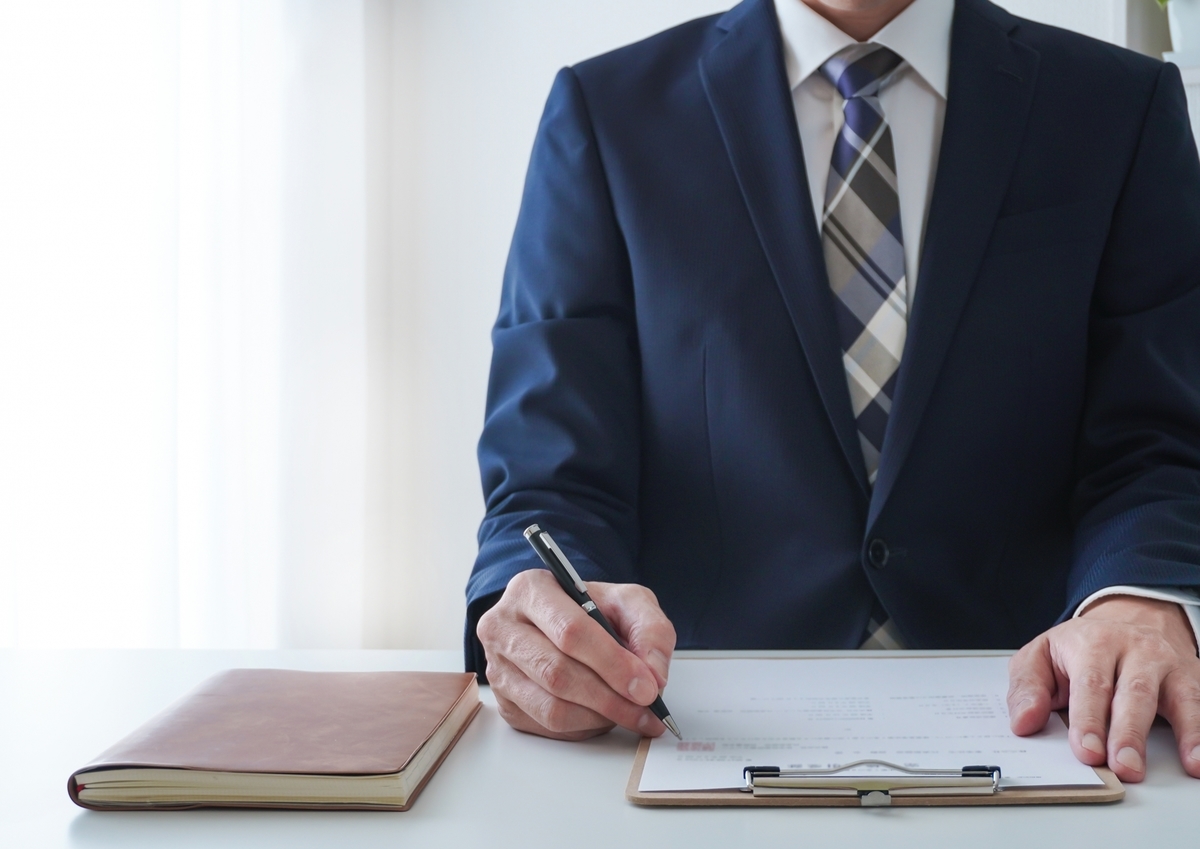 書類に記入するスーツを着た男性