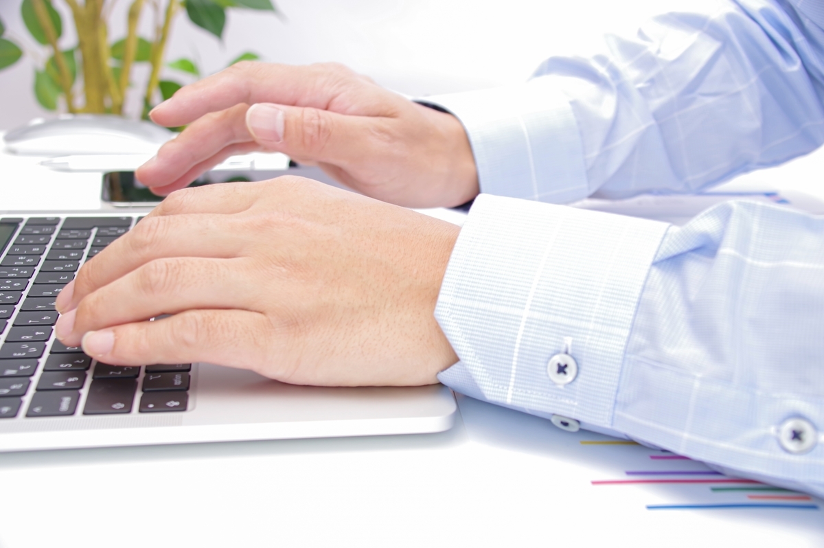 パソコン操作をする青いシャツを着た男性