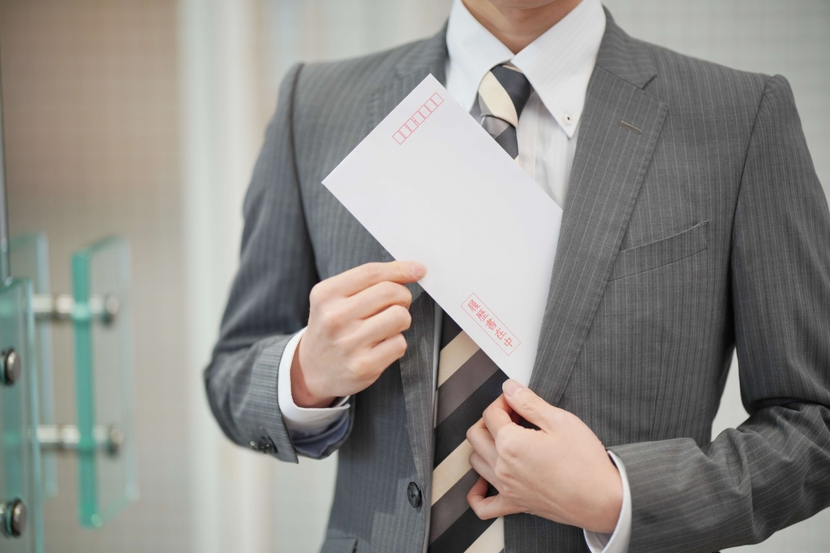 スーツの内ポケットに「履歴書在中」と書かれた封筒を差し込む男性