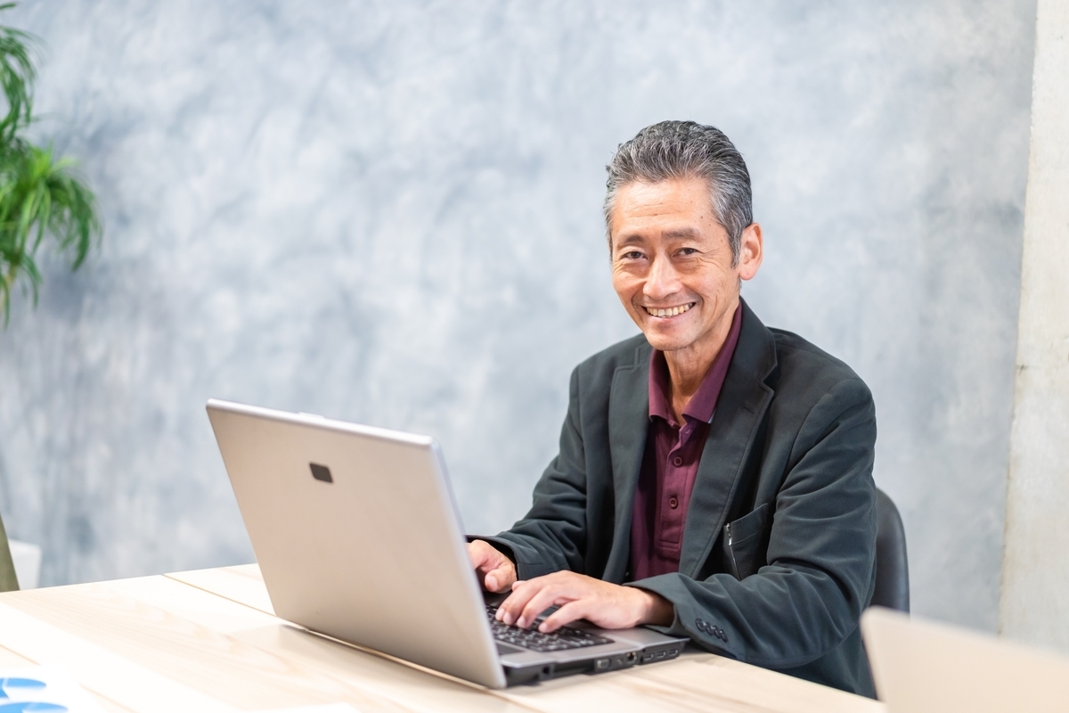 にこやかにパソコン操作をする男性