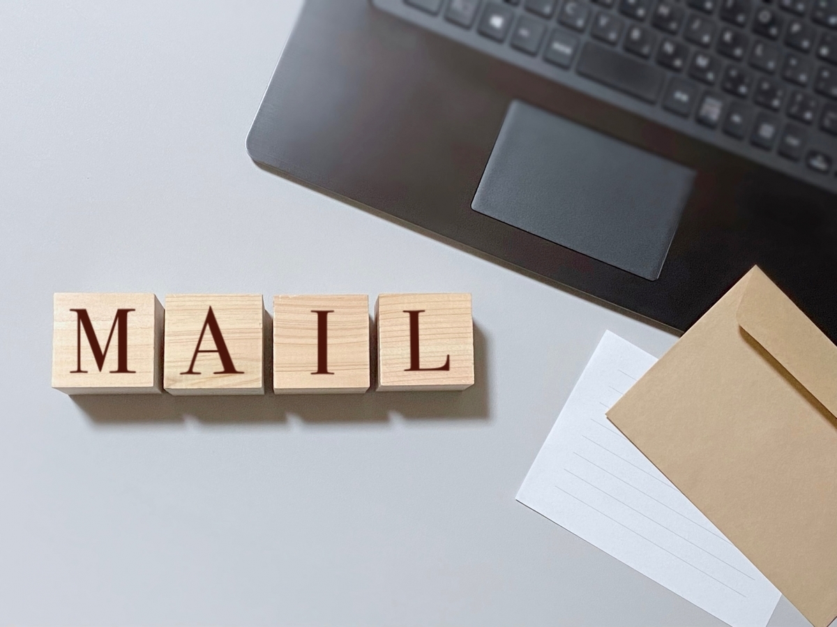 MAILと書かれた木のブロックと黒いノートパソコン