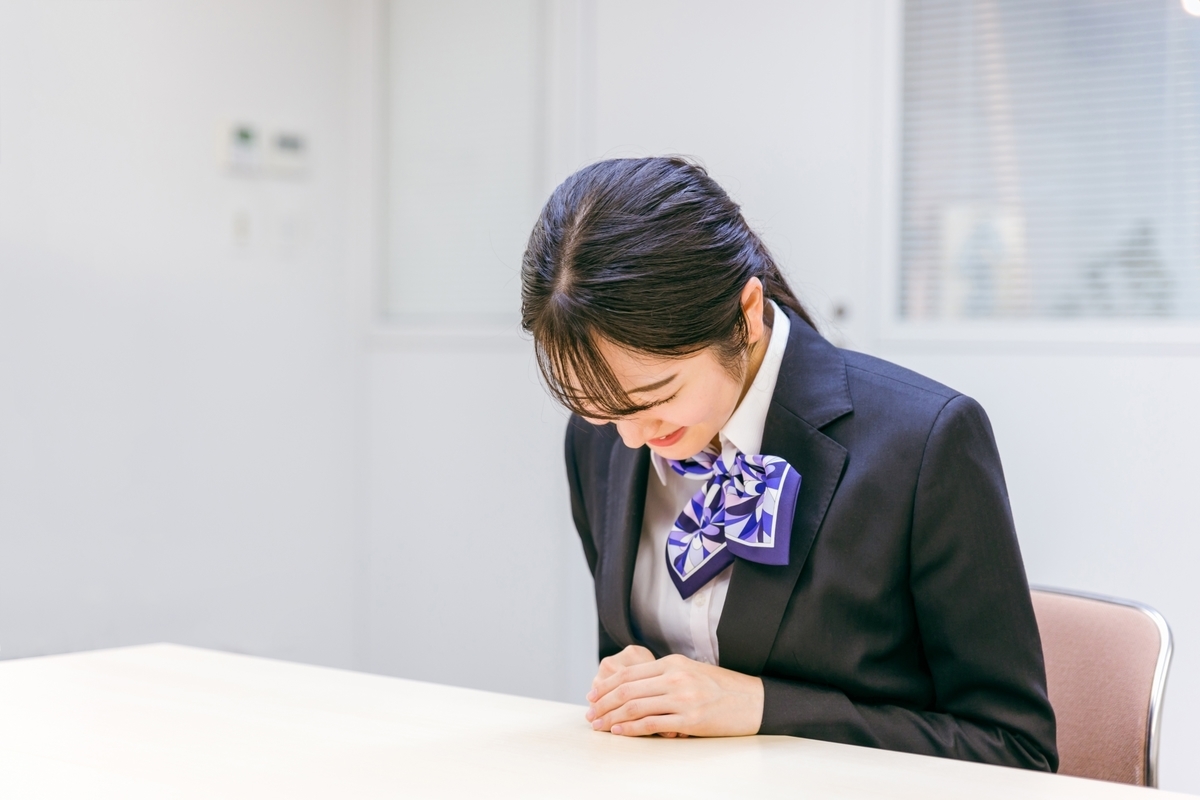 座りながらお辞儀をする女性