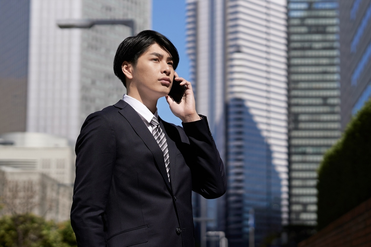外で電話をするスーツ姿の男性