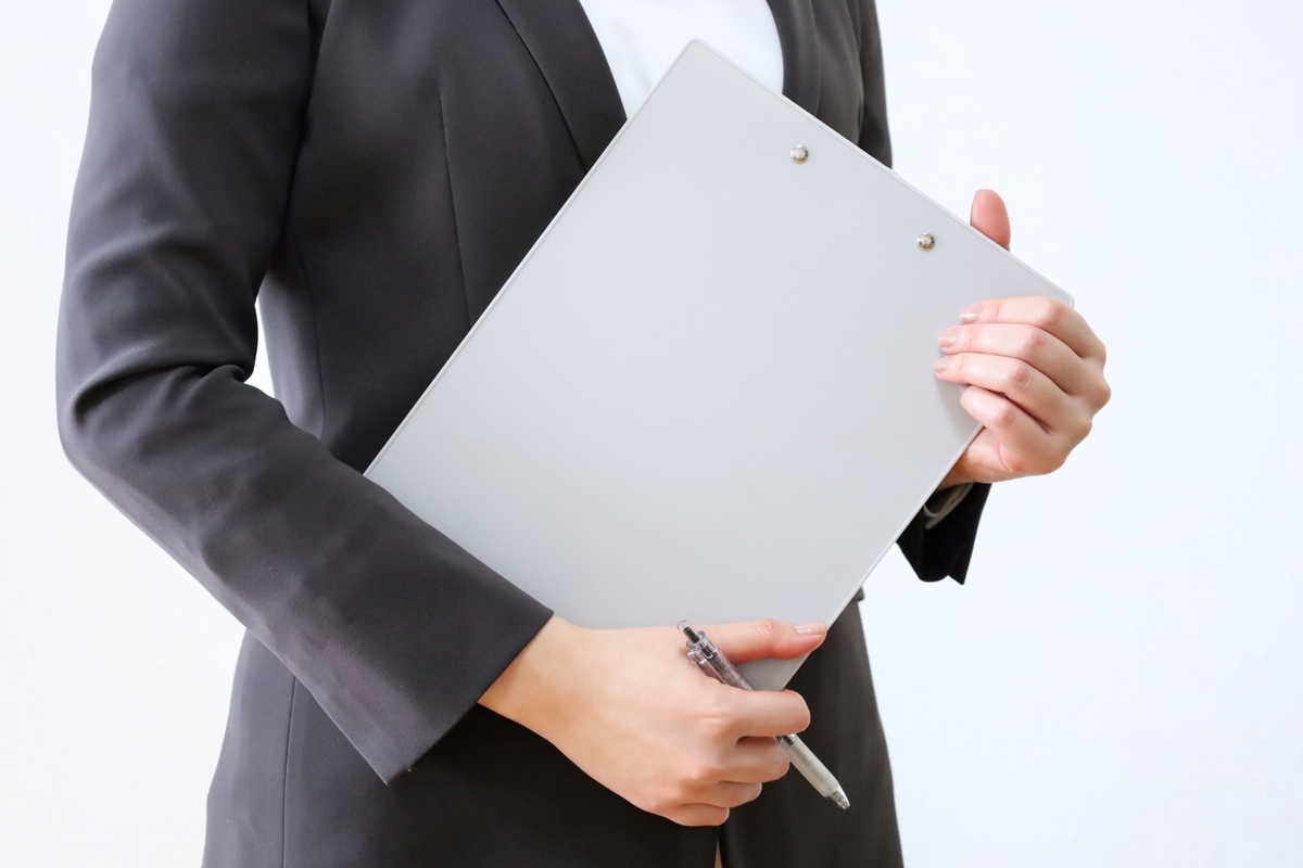 バインダーを持つスーツ姿の女性