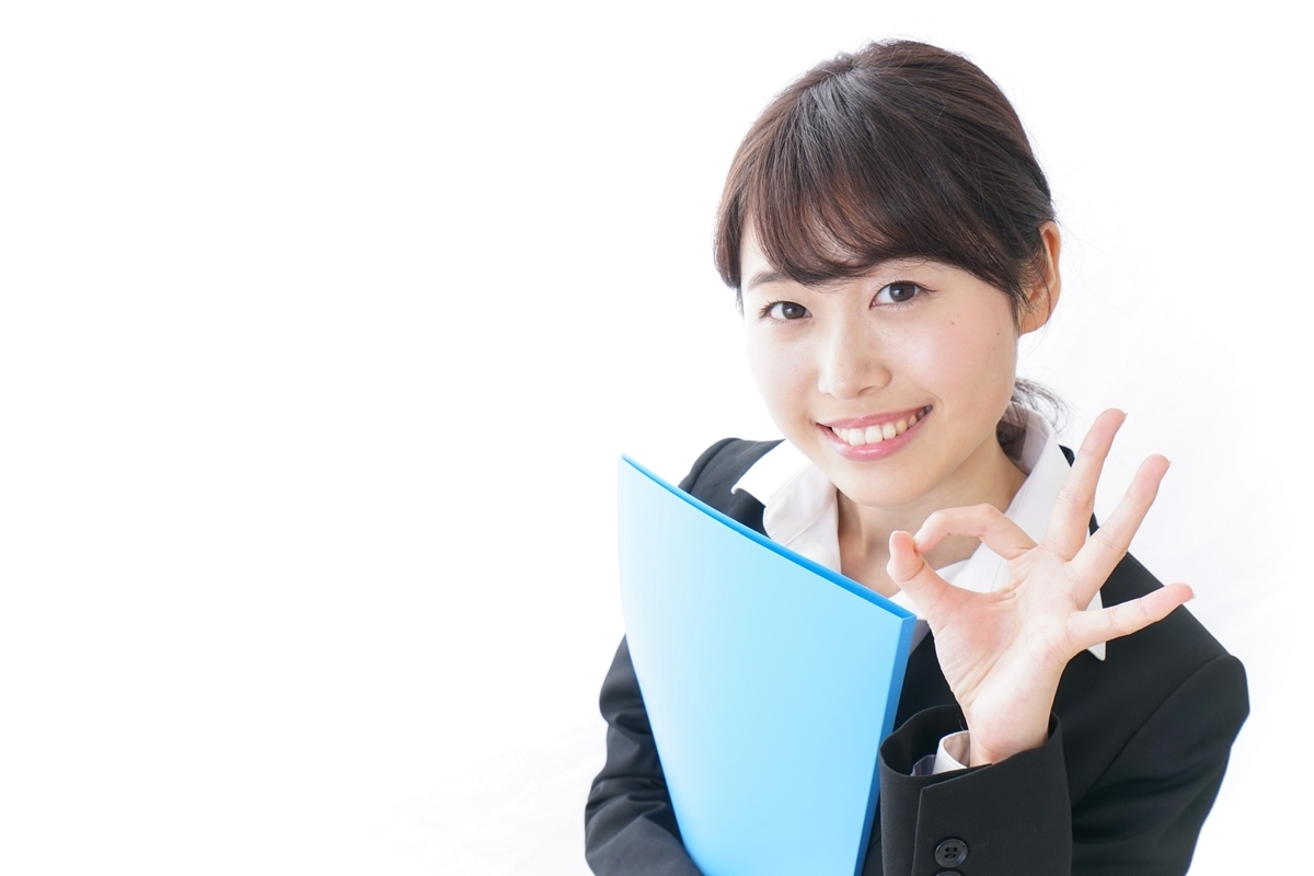 青いファイルをにこやかに持つOL