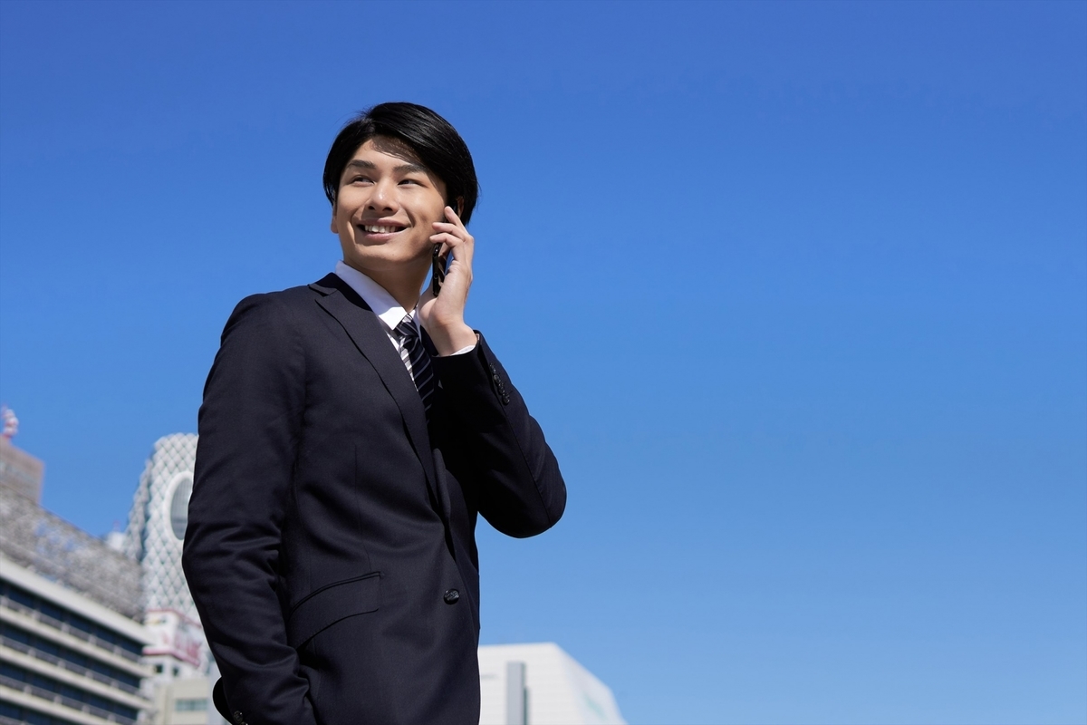 笑顔で外で電話をする男性
