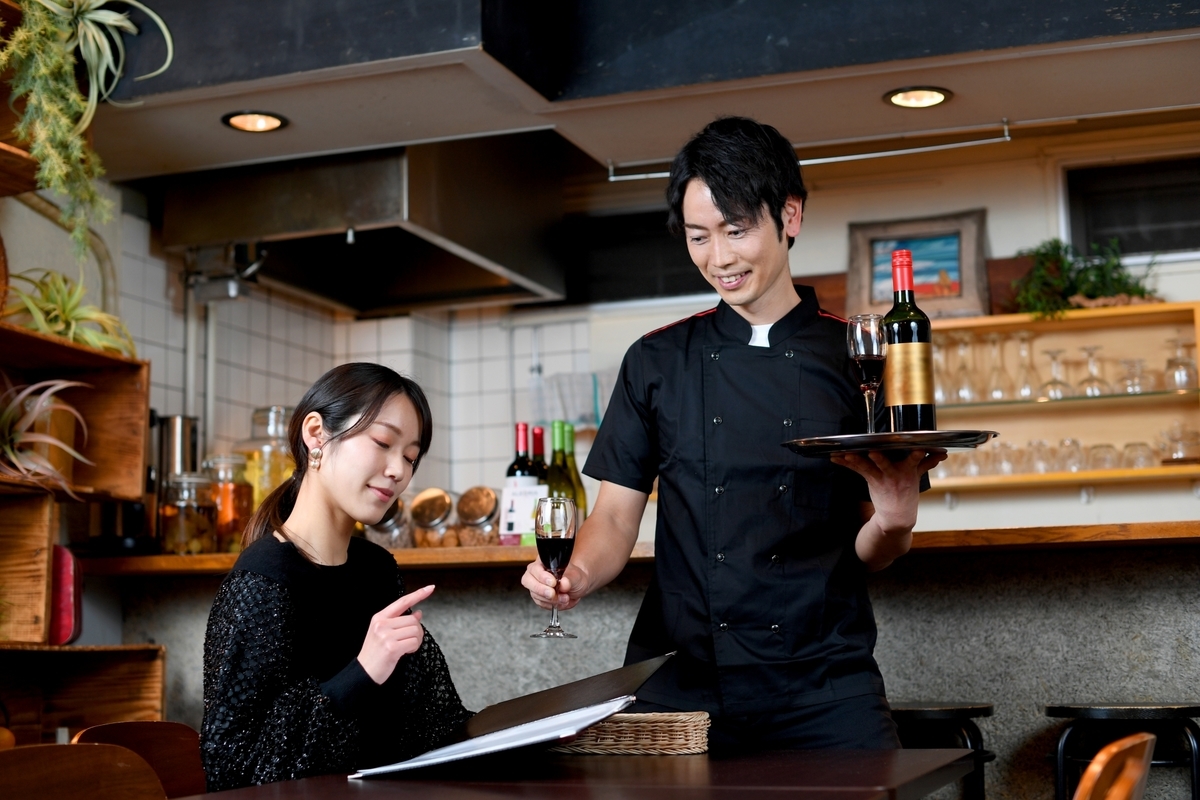 レストランでワインを注文する女性
