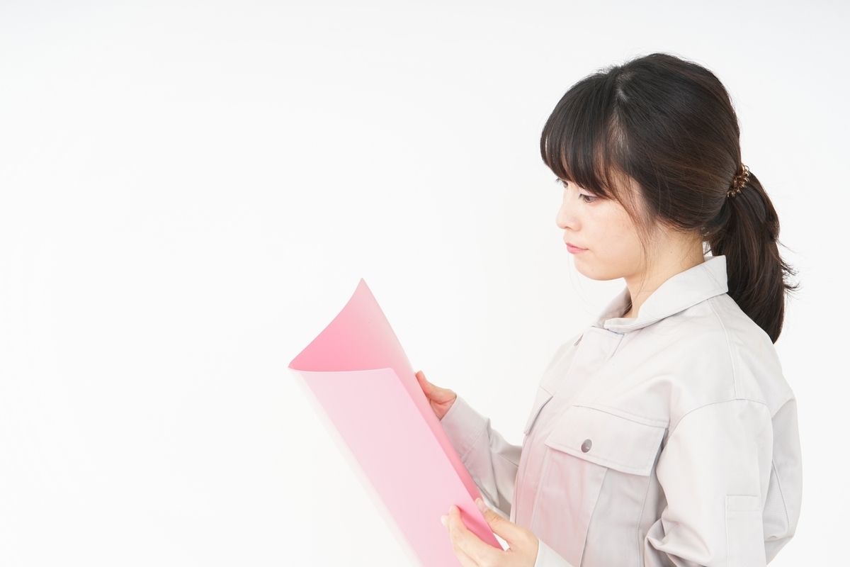 ファイルを見る作業服姿の女性