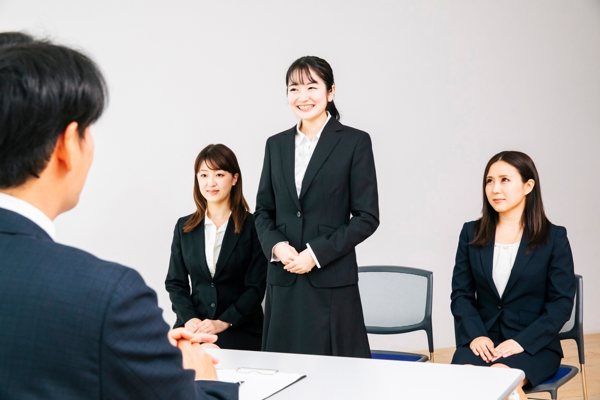 集団面接で笑顔で発言をする女性