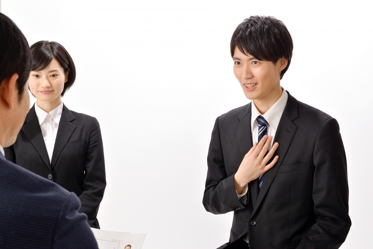 胸に手を当て発言する男性