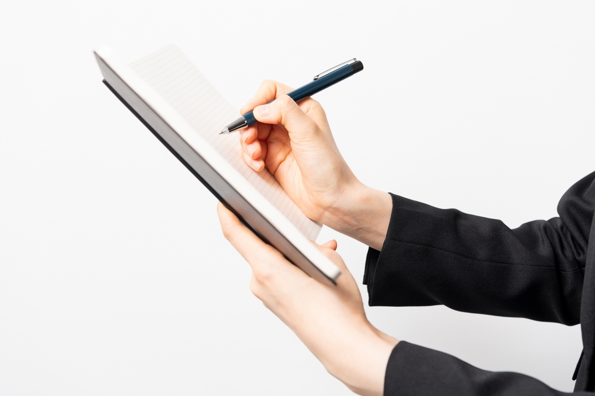 手帳に記入している手元