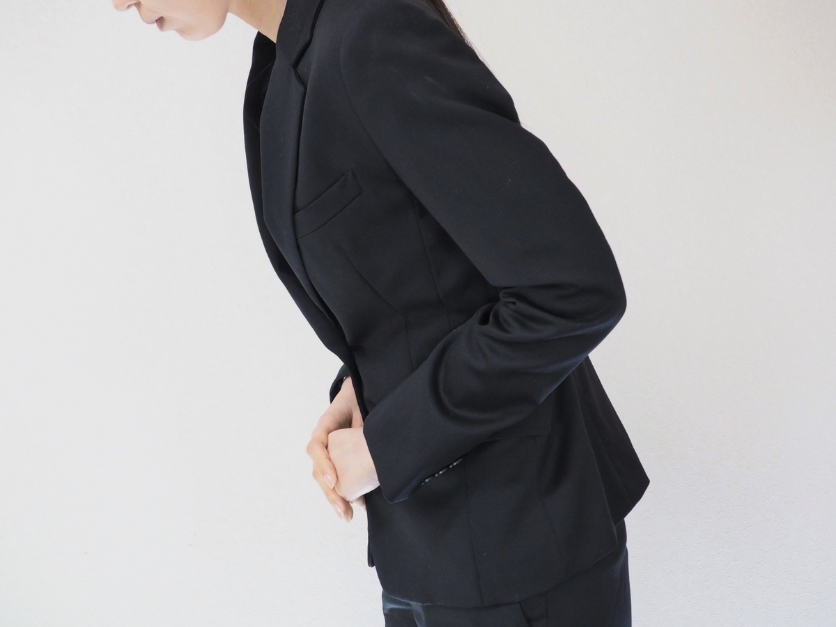 おじぎするスーツの女性