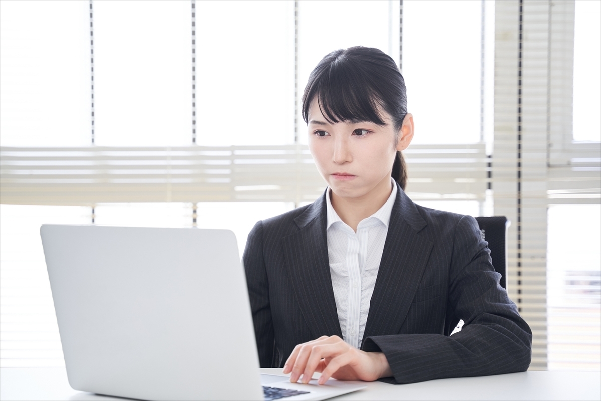 パソコンを前に考えている女性