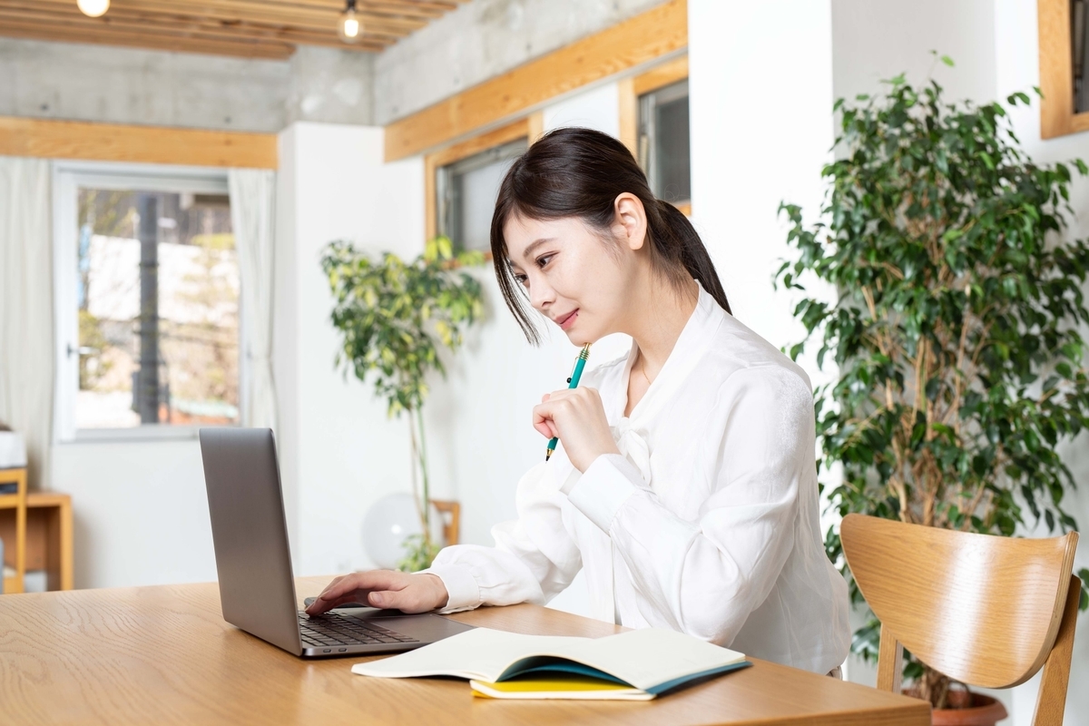 パソコンの前で考え事をしている女性