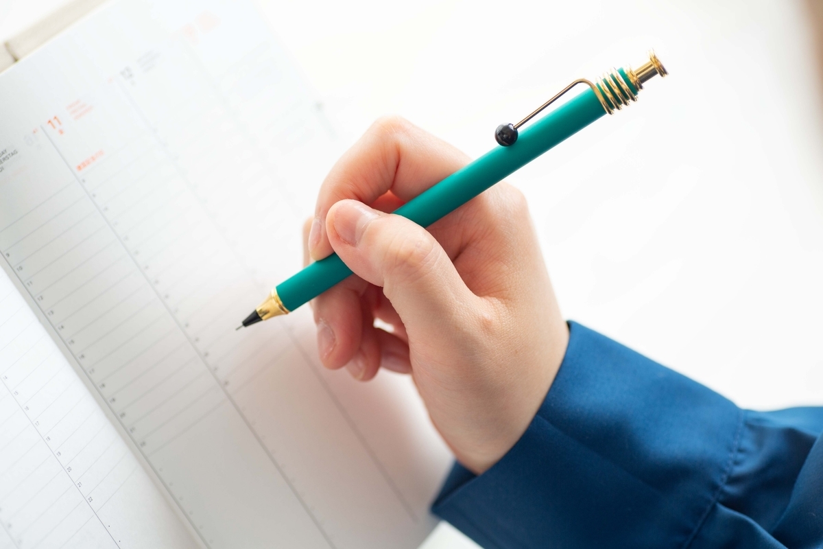 手帳に記入する手元