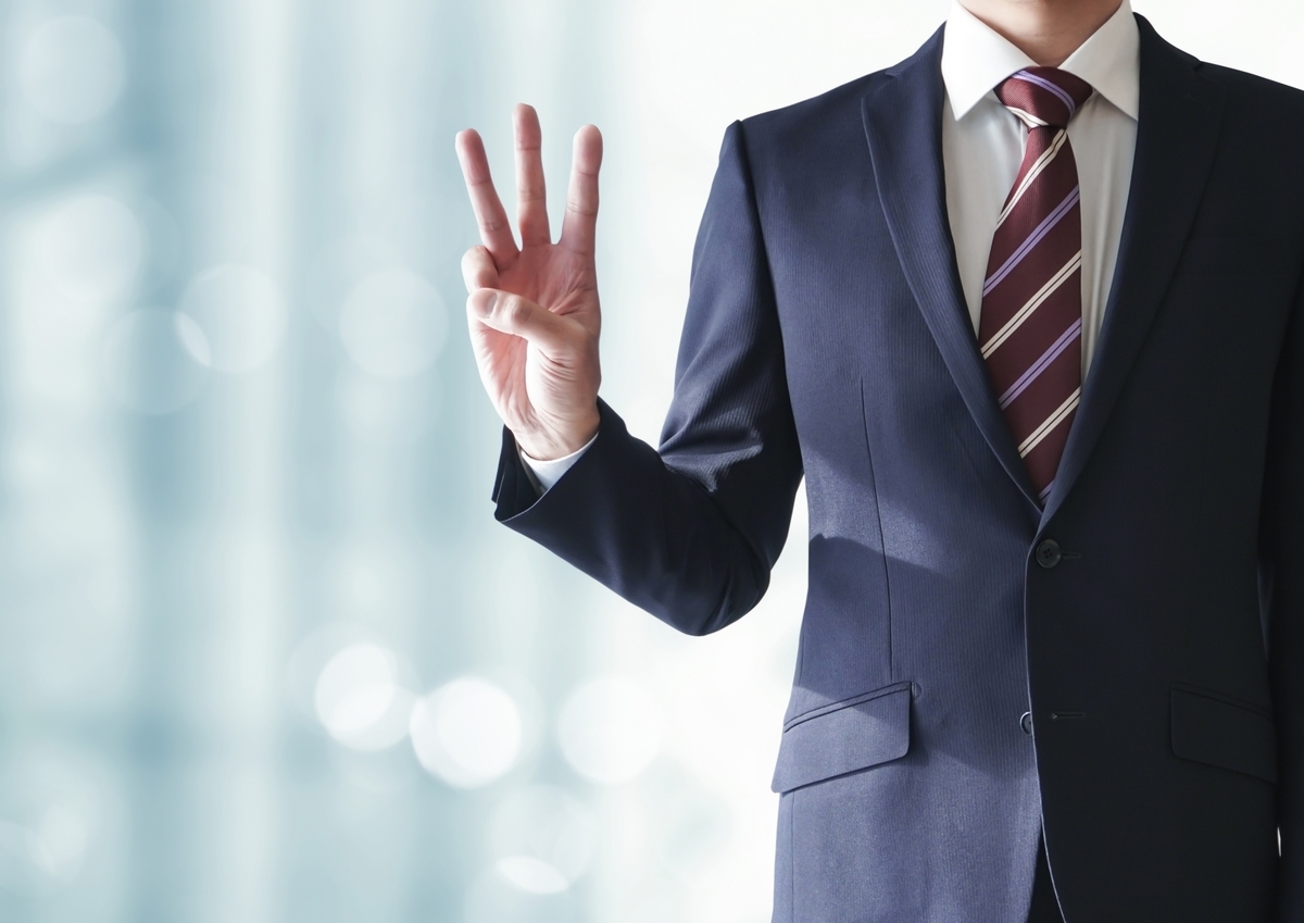 3を示すスーツの男性