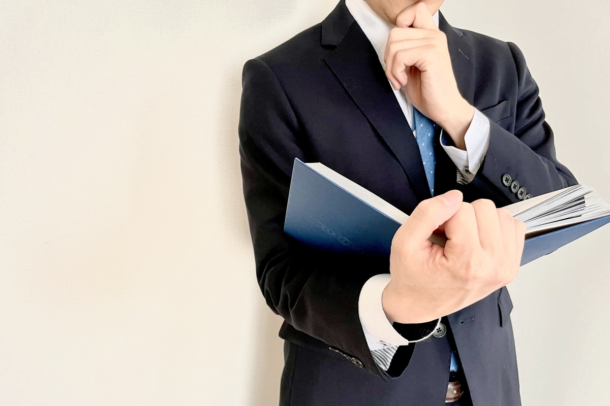 資料を手に考える男性