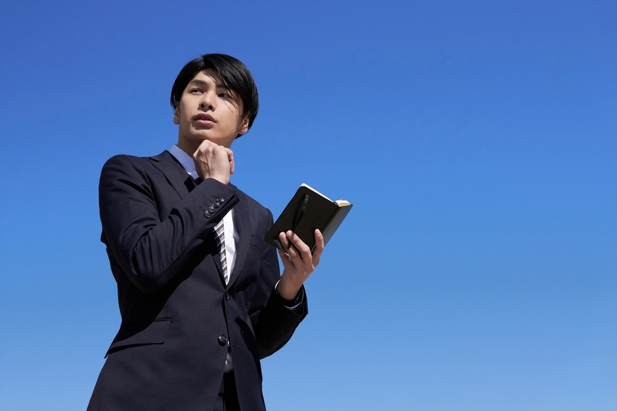 手帳を手にしている男性