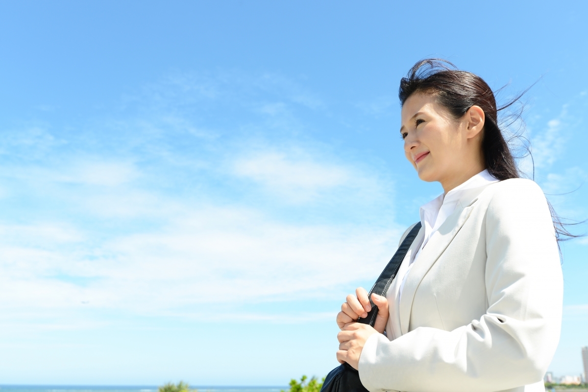 青空の下でスーツの女性