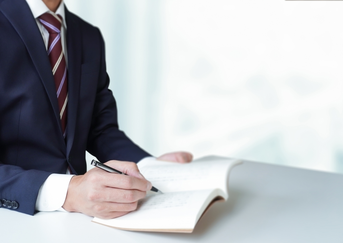手帳に記入する男性
