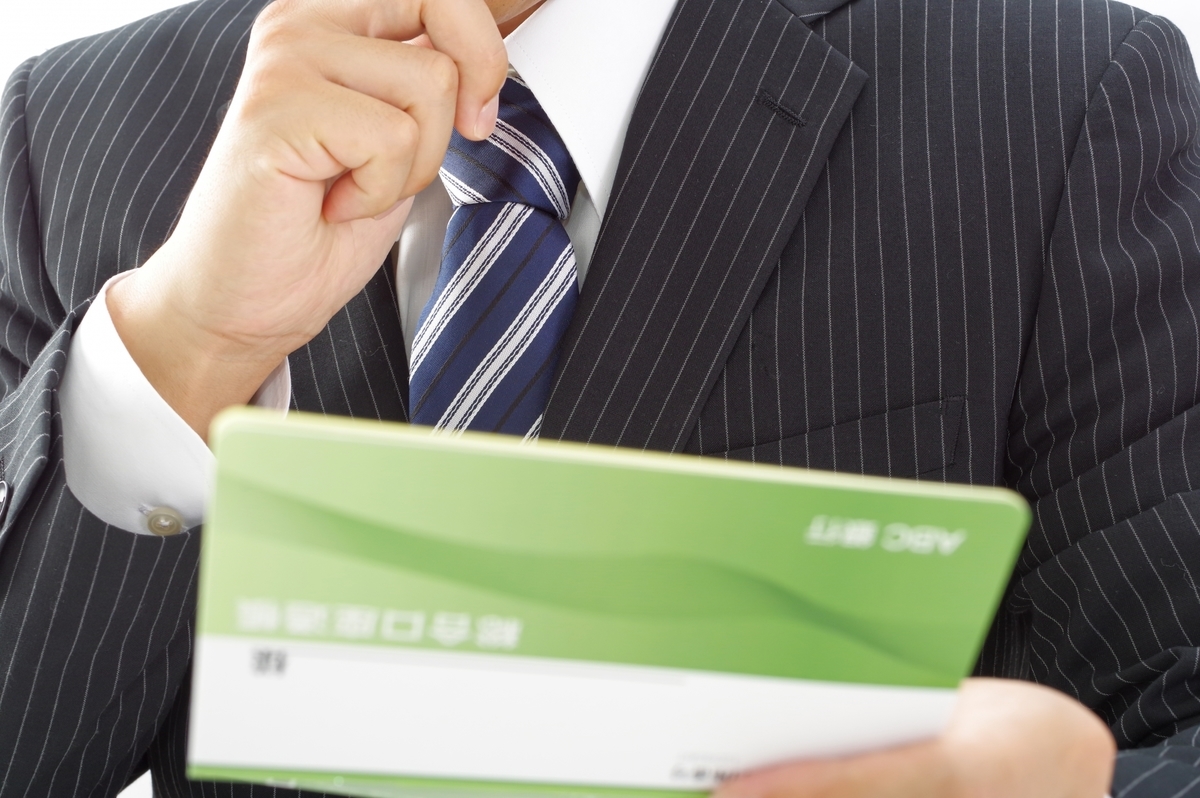 通帳を見て考える男性