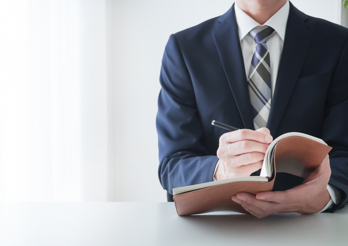手帳に記入する男性